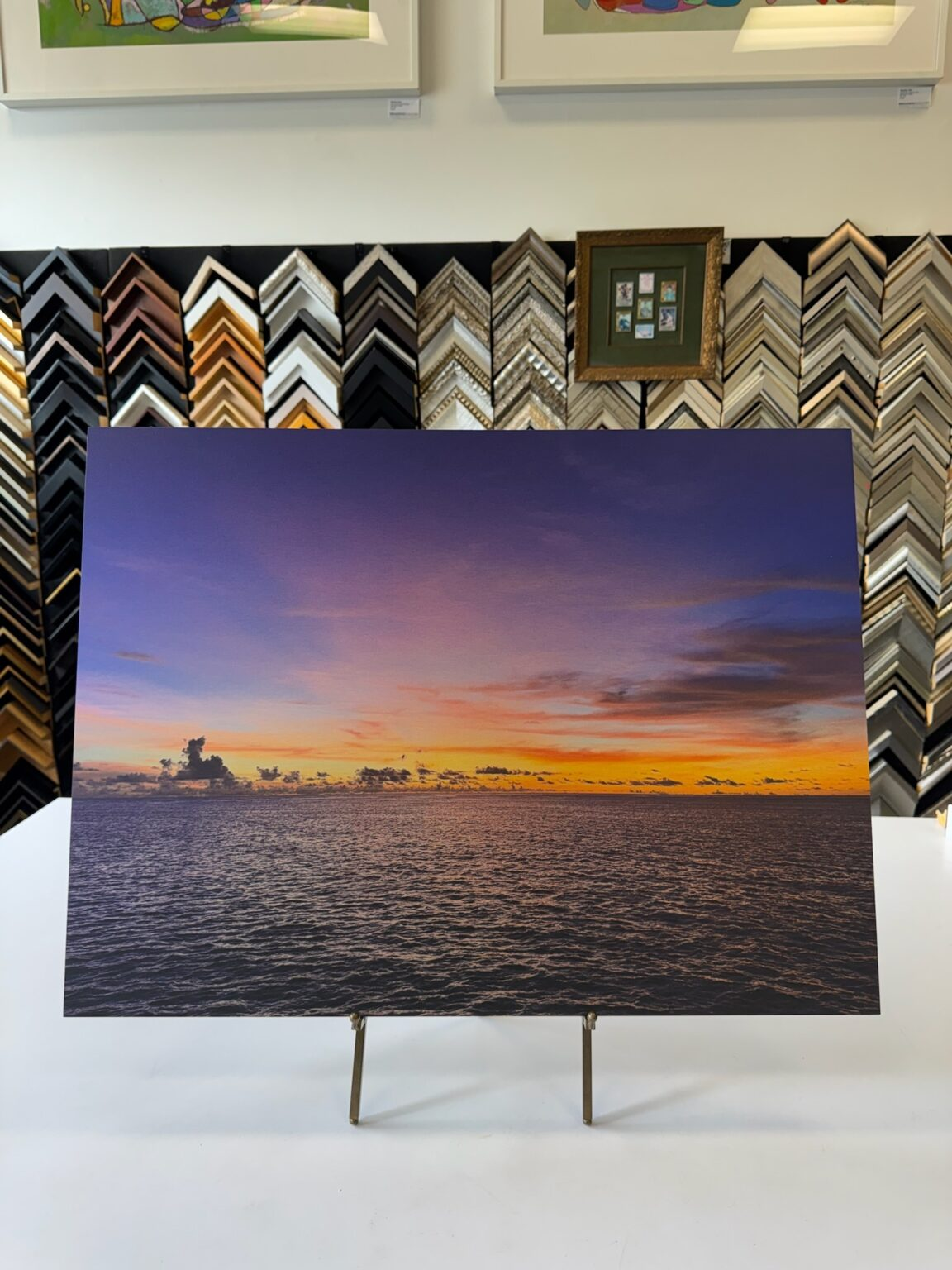Sunset over calm ocean waters with silhouetted horizon.