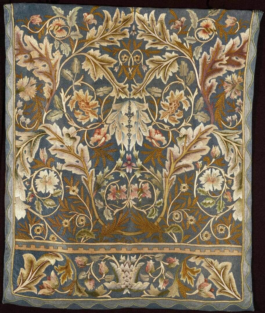 Ornate floral embroidery on blue fabric background.