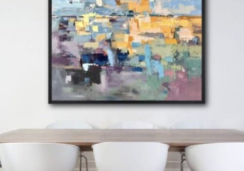 Abstract painting above dining table with chairs.
