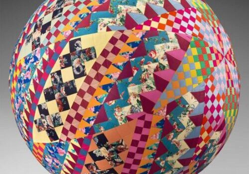 Colorful geometric-patterned sphere with quilt-like design.