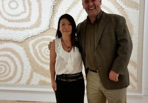 Man and woman posing in art gallery.