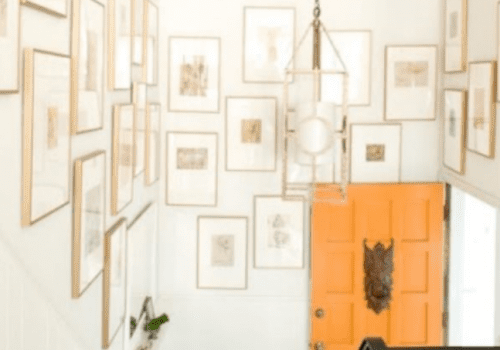 Orange door and framed pictures in hallway.