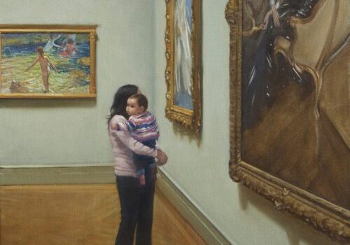 Woman holding baby in art gallery.