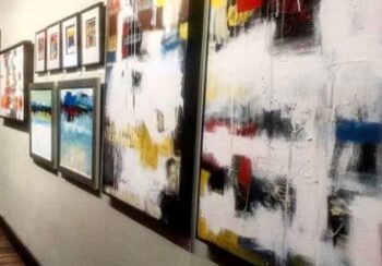 Abstract paintings displayed in a gallery hallway.